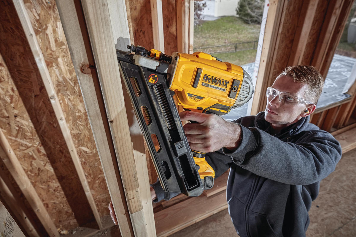 DEWALT cordless framing nailer on a stud wall